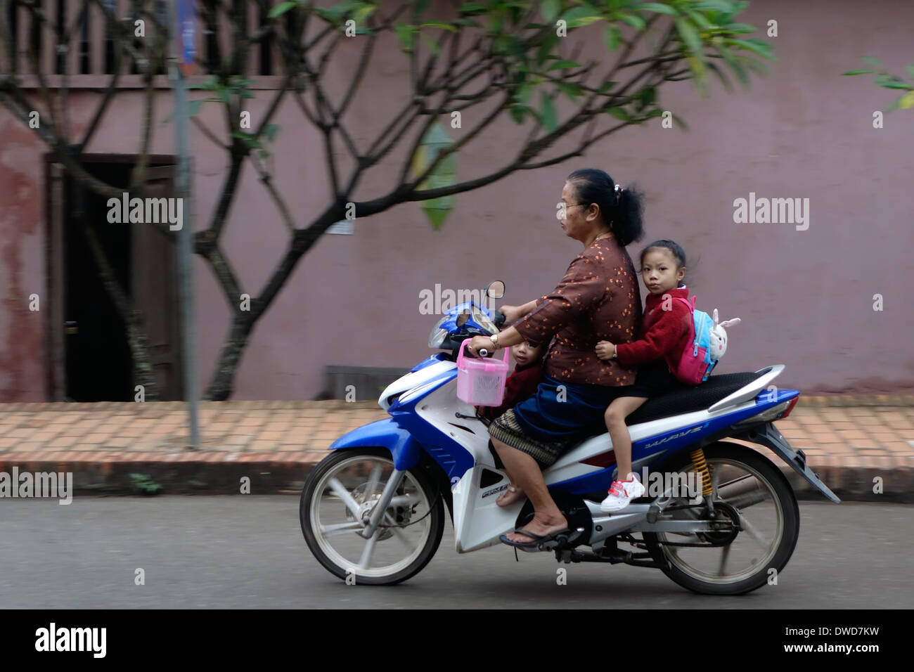 Mutter und Tochter auf einem Motorrad auf einer Straße in Luang Prabang, Laos. Stockfoto
