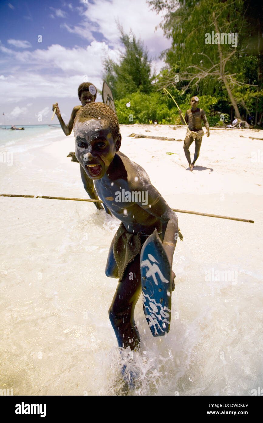 Eine Gruppe von jungen "Krieger" führen Sie die üblichen willkommen Angriff auf Kennedy Island, Salomonen, South Pacific Stockfoto