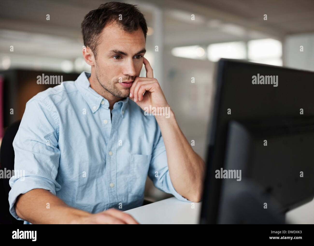 Geschäftsmann mit Desktop-PC am Schreibtisch im Büro Stockfoto