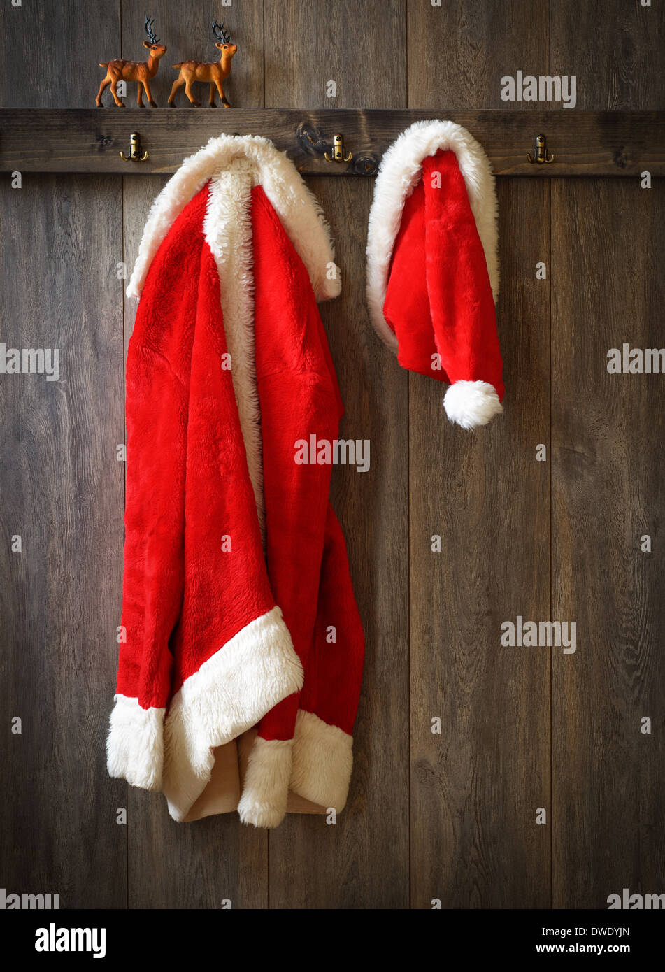 Santas Mantel und Hut aufhängen mit Rentier auf Sims Stockfoto
