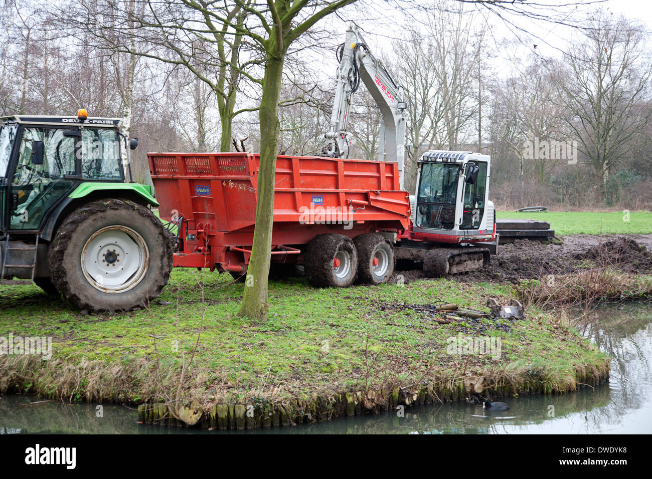 Traktor, Kran und Transport Fahrzeug arbeiten in einem park Stockfoto