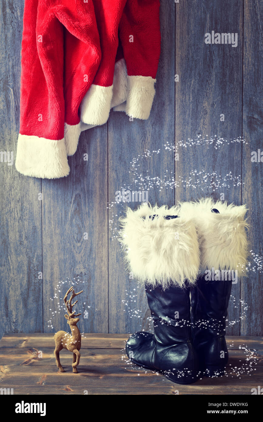 Santas schwarze Stiefel mit Pelzbesatz und hängende Jacke Stockfoto