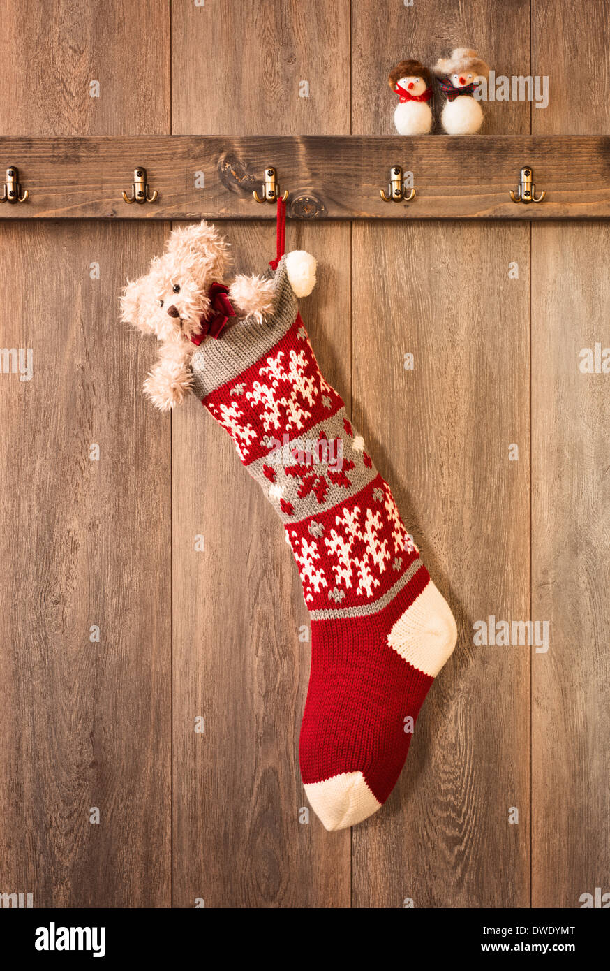 Teddybär in Weihnachts-Strumpf von Haken hängen Stockfoto