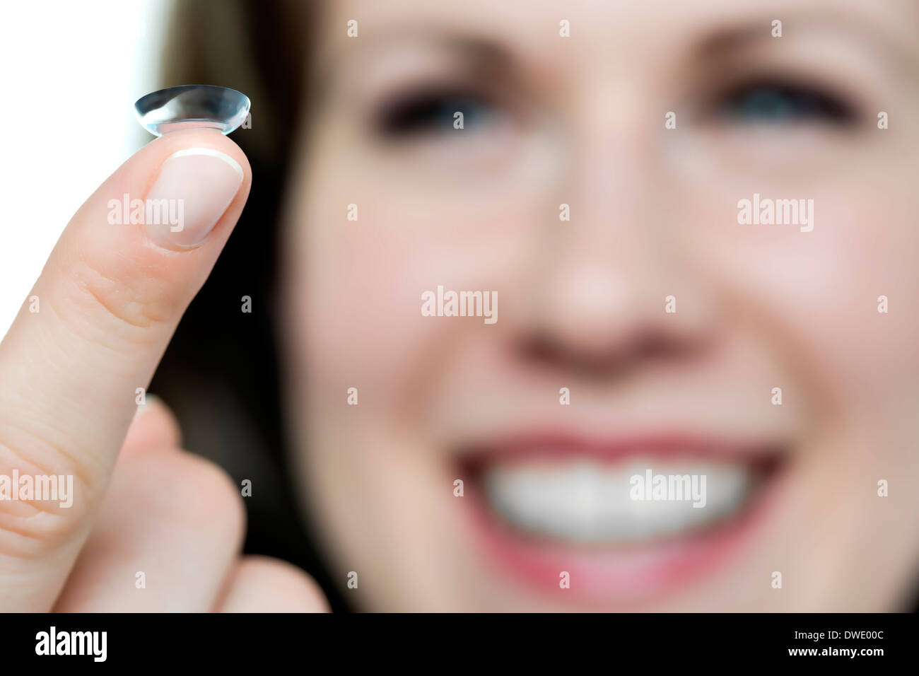 Nahaufnahme eines Gesichtes einer Frau mit einem Kontakt Linse am finger Stockfoto