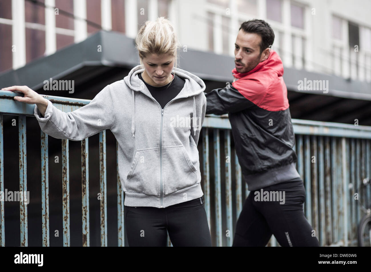 Sportliches Paar in Jacke von Geländern Stockfoto