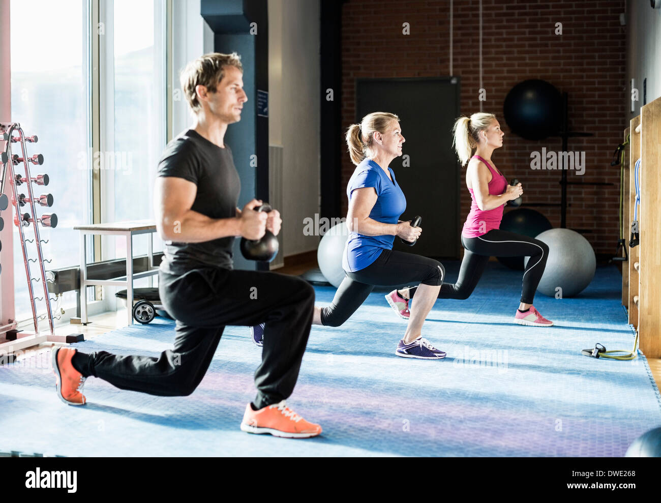 Kunden, die das Training mit Kettlebells in Turnhalle Stockfoto