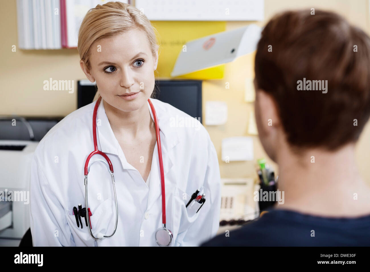 Junge Ärztin mit männlichen Patienten in der Klinik Stockfoto