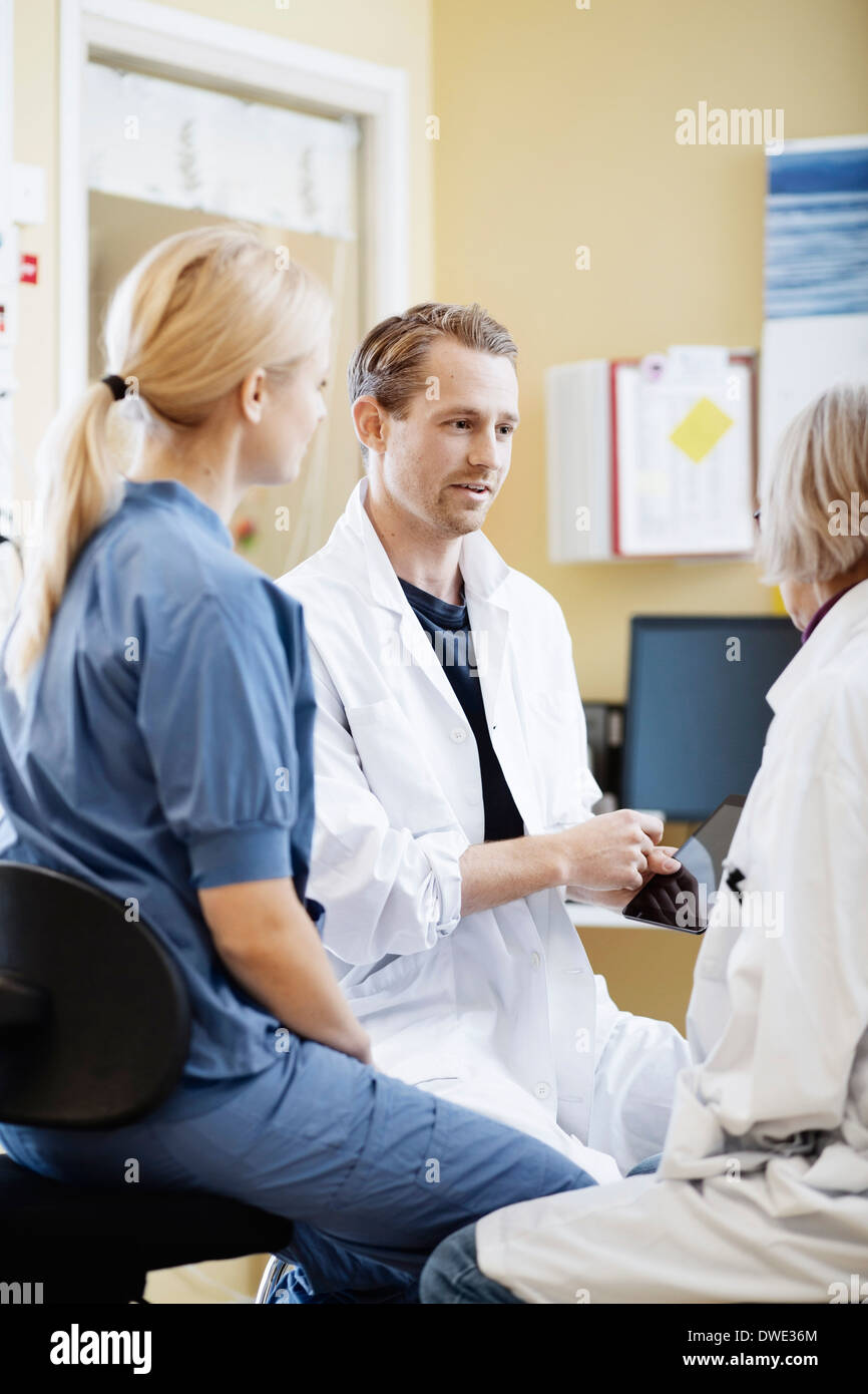 Ärzte und Krankenschwester diskutieren über digital-Tablette im Krankenhaus Stockfoto