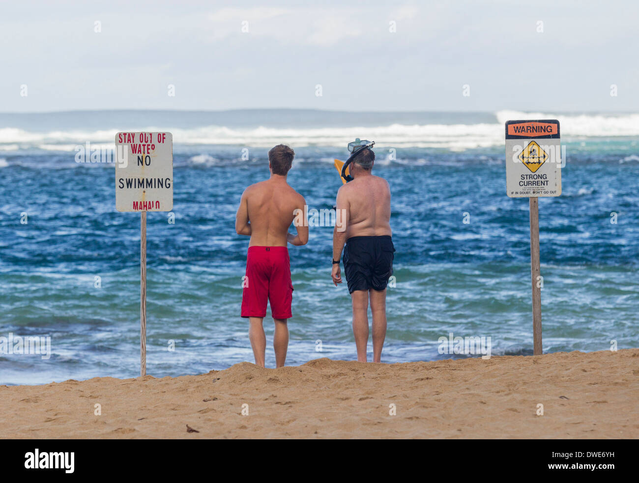 Tunnels Beach, Kauai, Hawaii, USA - zwei Schwimmer, die Entscheidung, ob in den tückischen Winter Gewässern schwimmen Stockfoto
