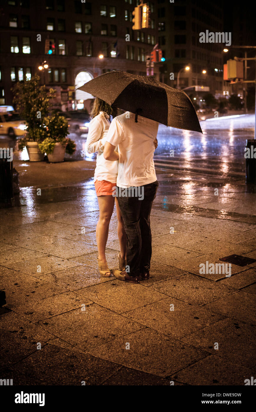 Ein junges Paar Klammern sich an einander ins Tierheim von einem Regenguss Stockfoto