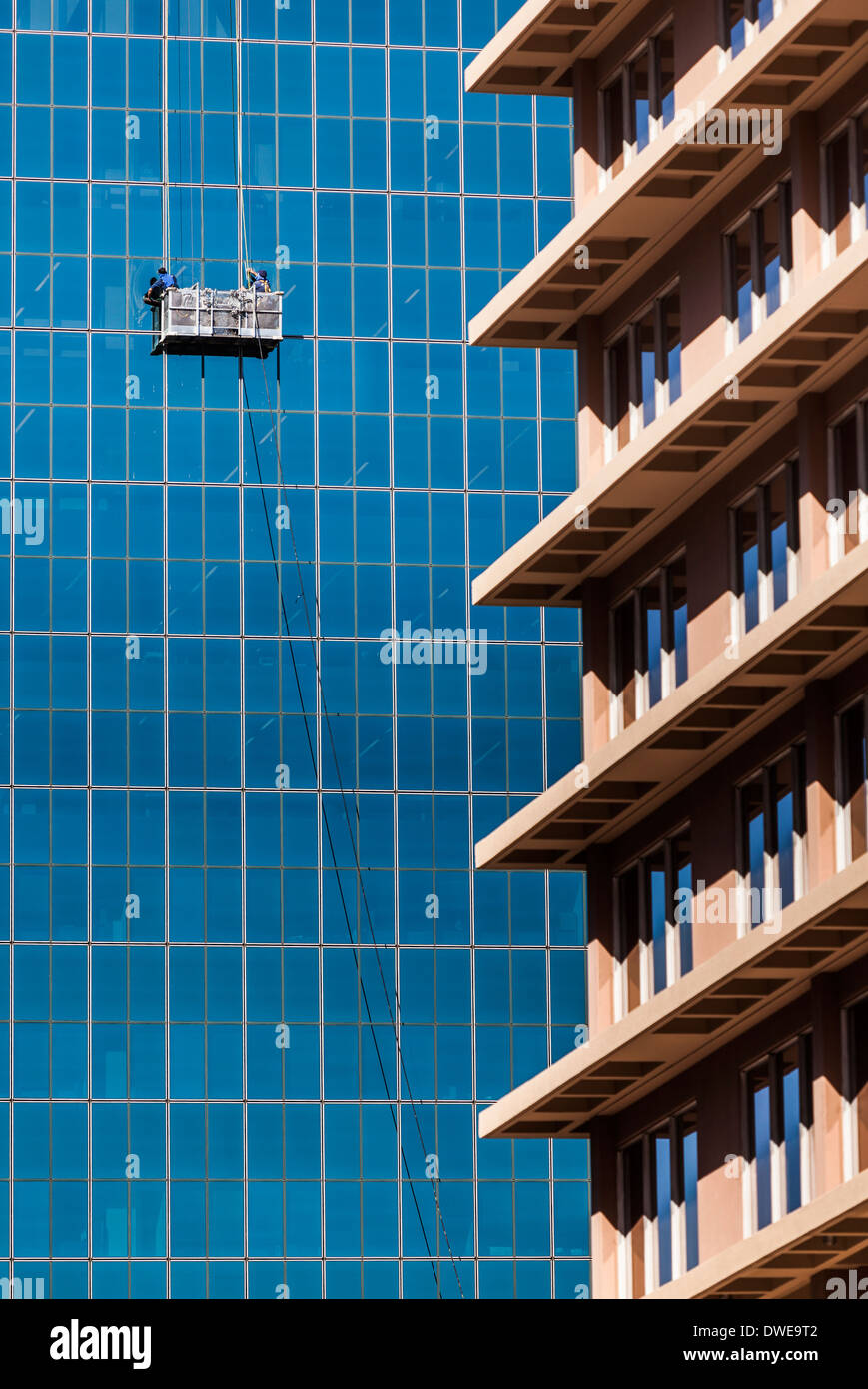 Fensterputzer in Angriff nehmen die monumentale Aufgabe der Reinigung eines Wolkenkratzers. Stockfoto