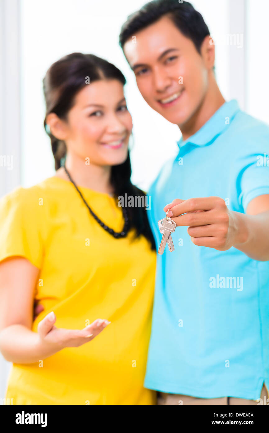 Young Asian hübscher Mann mit Freundin Schlüssel zu seiner Wohnung oder Haus einziehen Stockfoto