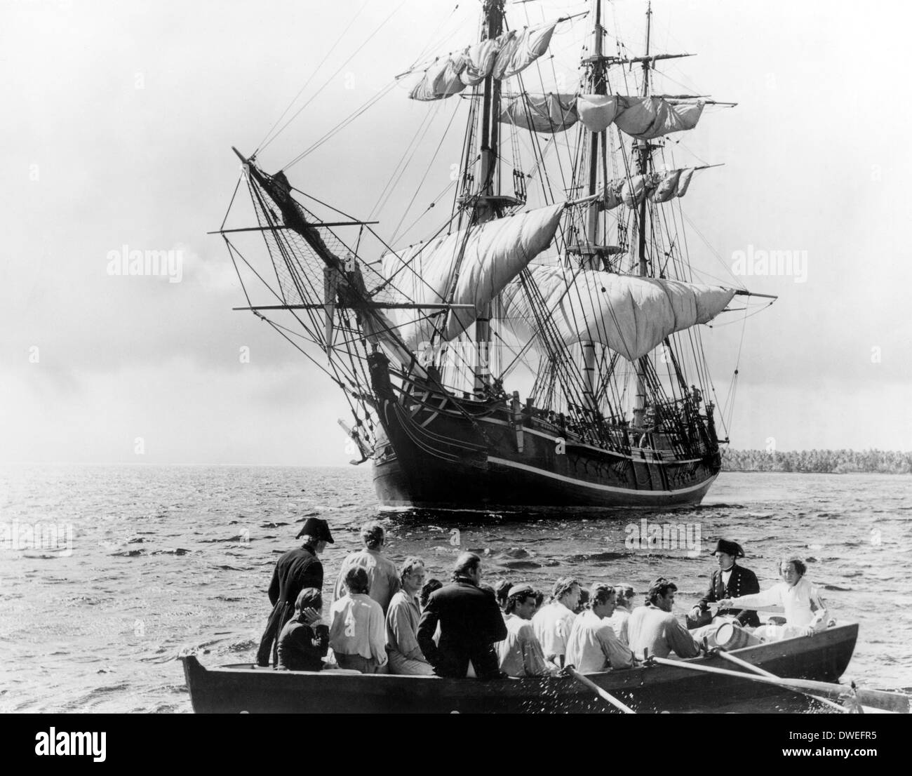 Trevor Howard und Crew treiben in Longboat mit HMS Bounty im Hintergrund, am Set des Films, "Meuterei auf der Bounty", Regie: Lewis Milestone, 1962 Stockfoto