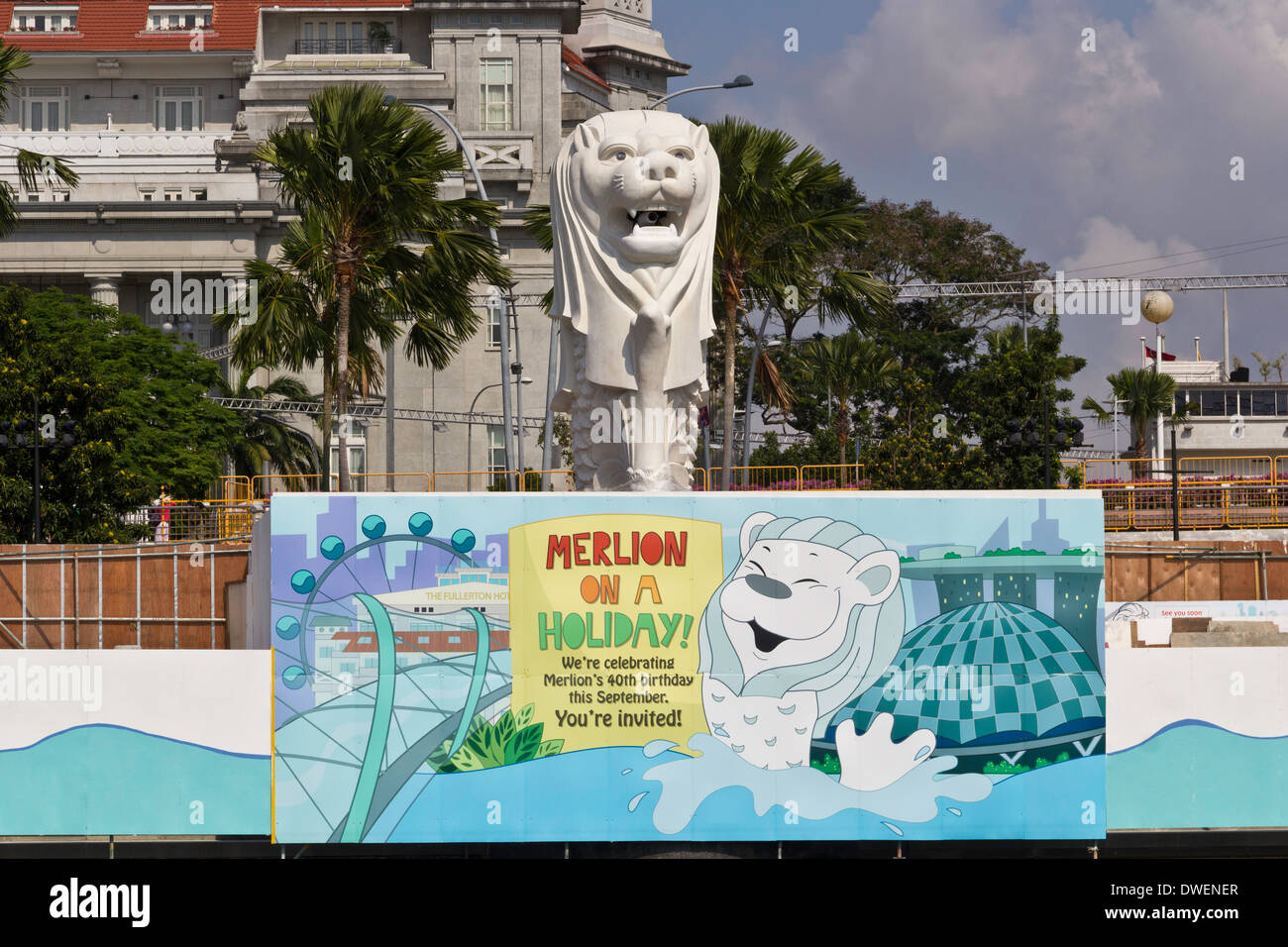 Die Statue der Merlion mit Banner unterhalb der Statue und Gebäude und Bäume im Hintergrund. Merlion ein Wahrzeichen von Singapur Stockfoto