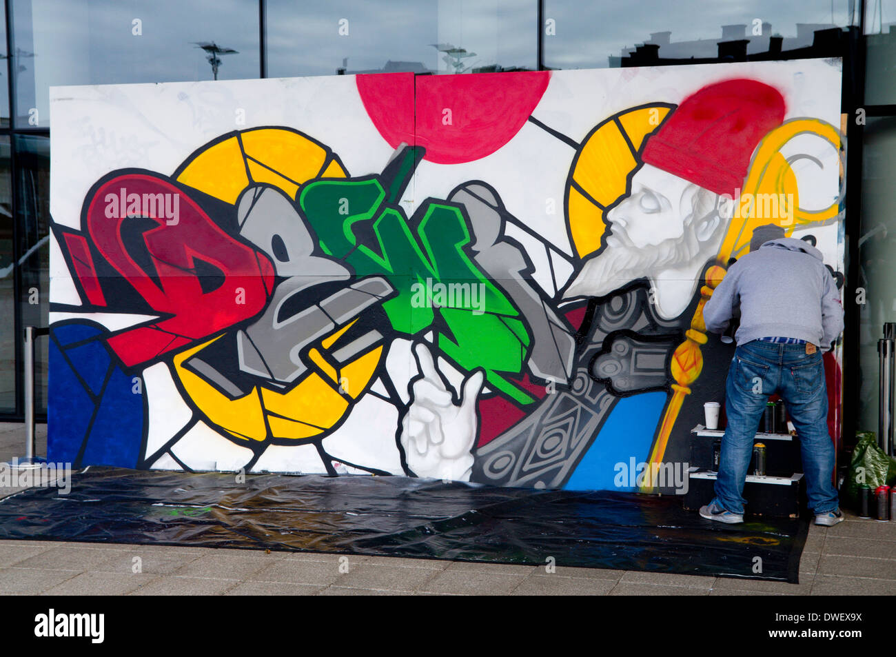 Graffiti Künstler sprühen St Davids Day Art arbeiten, Millennium Centre, Cardiff, Wales. Stockfoto