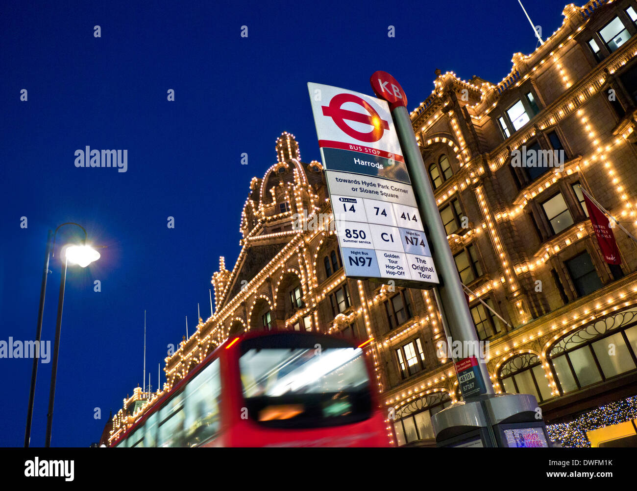 KNIGHTSBRIDGE und Harrods Kaufhaus Bus in der Nacht mit eigener Bushaltestelle und verschwommen red London Bus Knightsbridge London UK Stockfoto