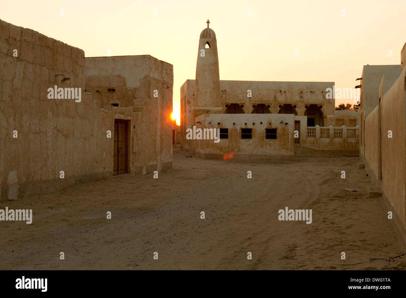 Sonnenuntergang am traditionellen Häusern und Minarett neben Strand in Al Wakra, Katar Stockfoto