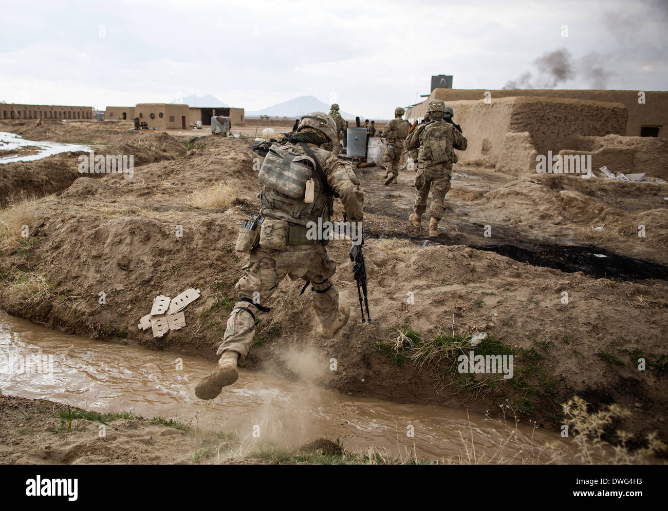 US-Armeesoldaten springen über eine Bewässerung Graben während einer Patrouille der Aufklärung in einem Dorf im Rahmen der Operation Alamo Scout 12. Februar 2014 in der Provinz Kandahar, Afghanistan. Stockfoto