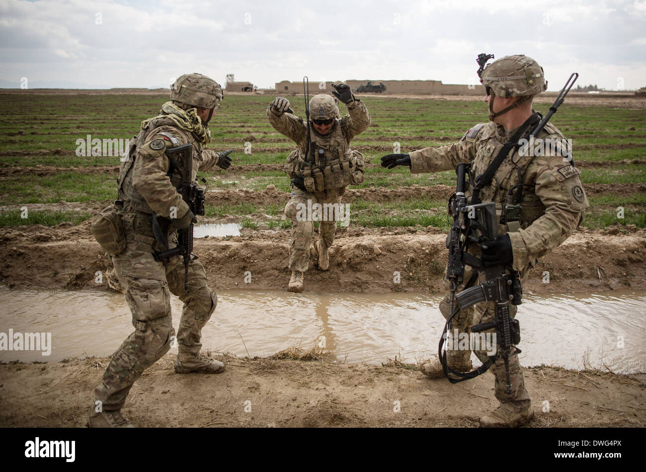 US-Armeesoldaten springen über eine Bewässerung Graben während einer Patrouille der Aufklärung im Rahmen der Operation Alamo Scout 12. Februar 2014 in der Provinz Kandahar, Afghanistan. Stockfoto