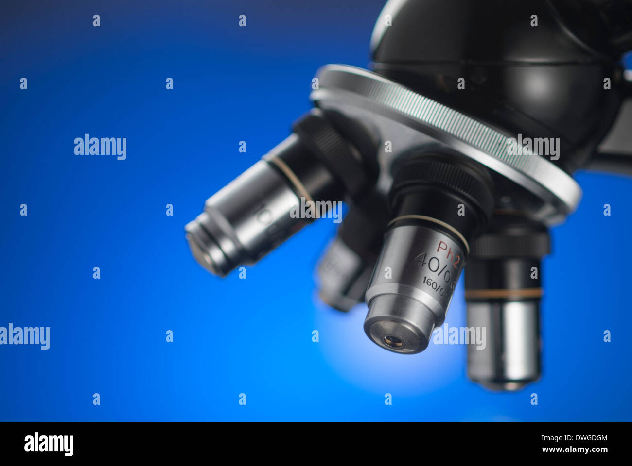 Nahaufnahme eines Mikroskops Turm Gegenlicht durch blauen Gradienten mit sehr wenig Schärfentiefe Stockfoto