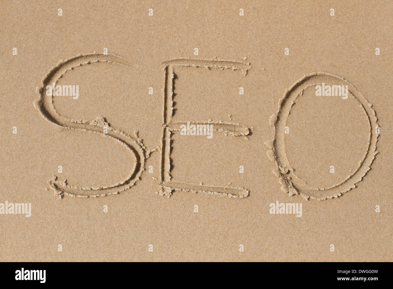 Zeichnung der Buchstaben SEO in Sand. Stockfoto