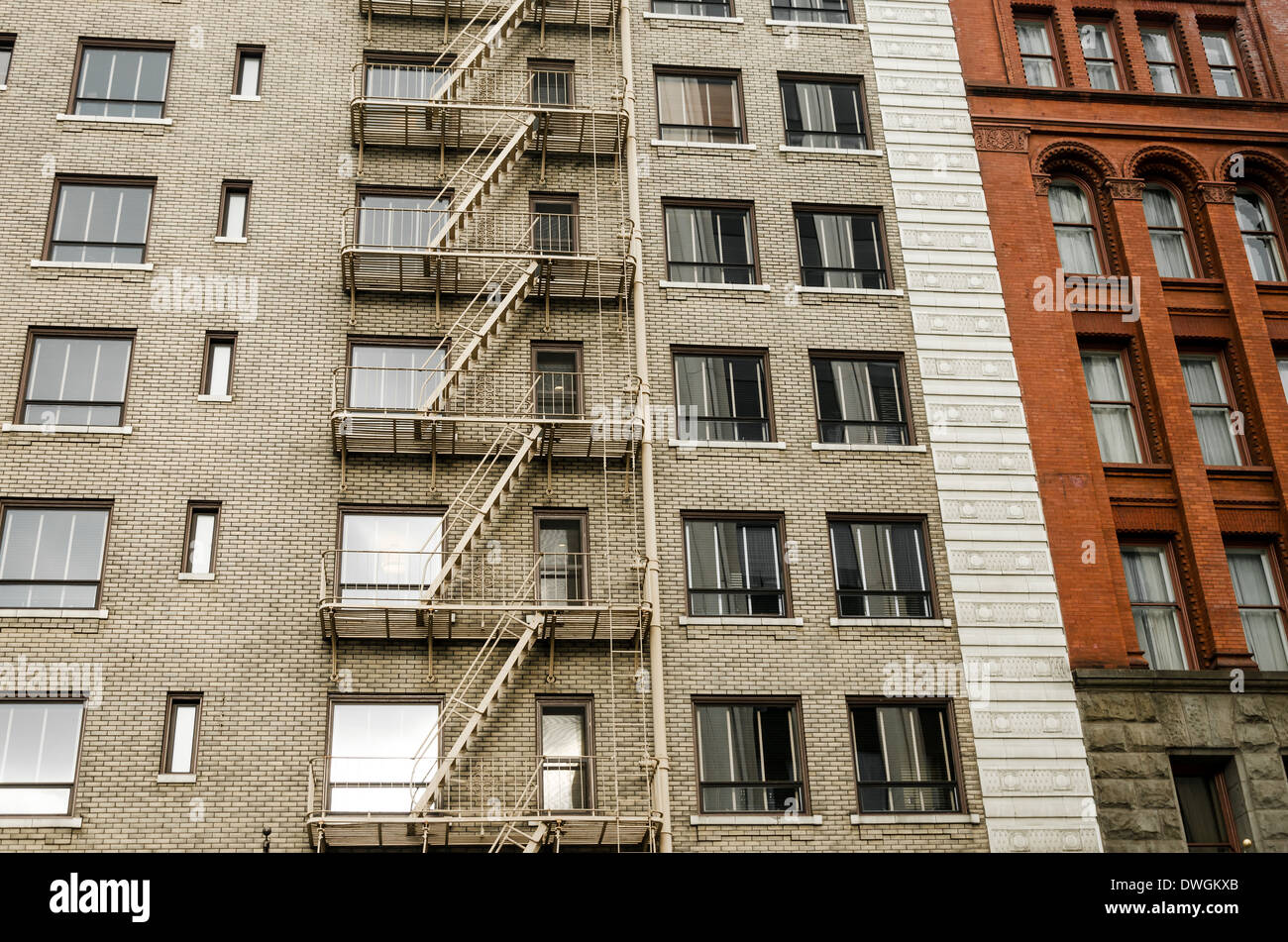 Zwei andere Farbe Backsteinbauten, eins mit einer Feuertreppe läuft nach unten der Seite davon in Portland, Oregon Stockfoto