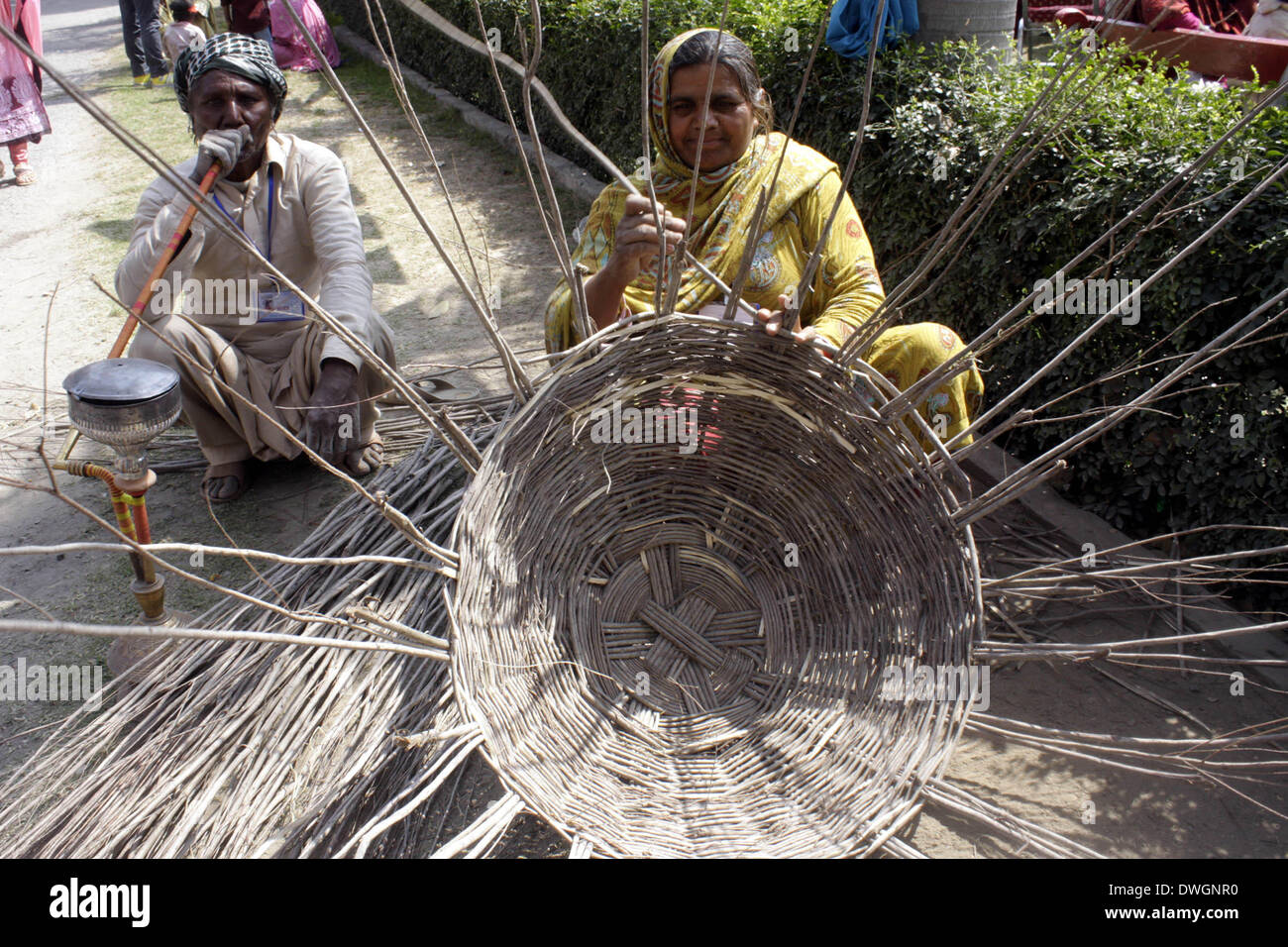 Lahore. 8. März 2014. Eine pakistanische Frau macht handgefertigte Korb im östlichen Pakistan Lahore, 8. März 2014, dem internationalen Frauentag ist. Frauen haben nur begrenzte Möglichkeiten in Pakistans sehr traditionellen, patriarchalischen Gesellschaft. Die Vereinten Nationen sagt nur 40 Prozent der Erwachsenen Frauen können lesen und schreiben, und sie sind häufig Opfer von Gewalt und Missbrauch. © Jamil Ahmed/Xinhua/Alamy Live-Nachrichten Stockfoto