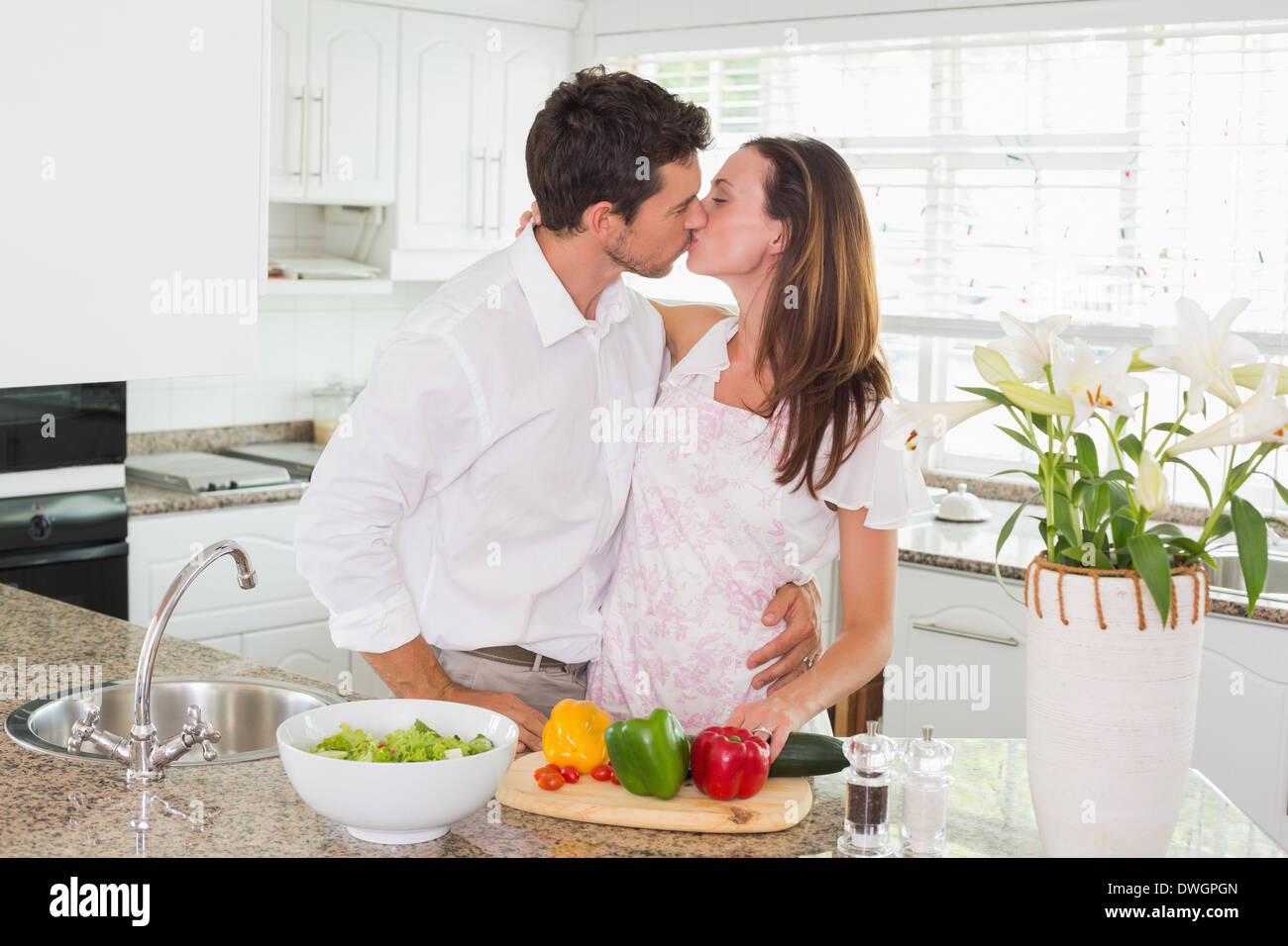 Liebendes Paar küssen in der Küche Stockfoto