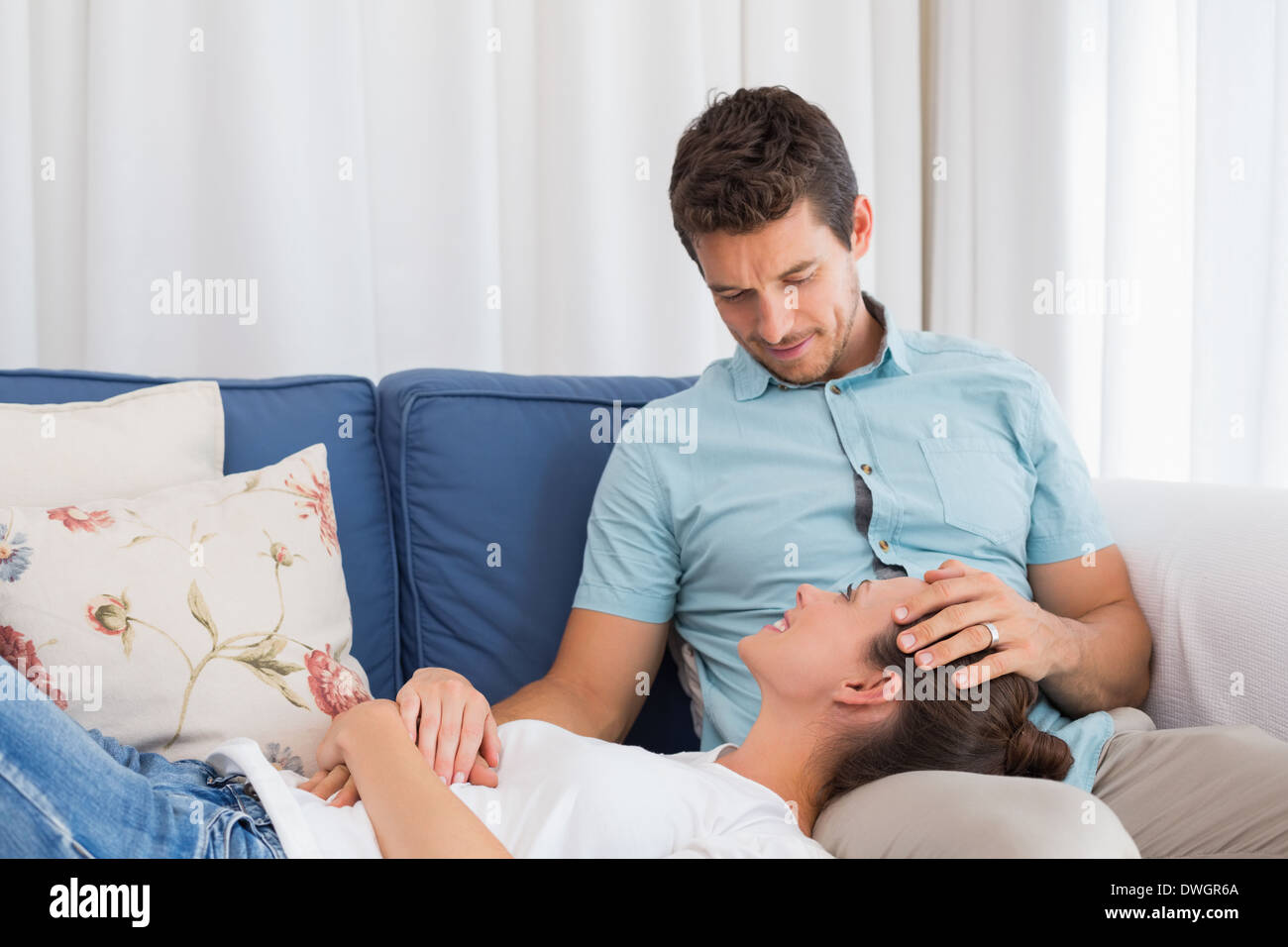 Entspannte Frau ruht auf mans Runde auf couch Stockfoto