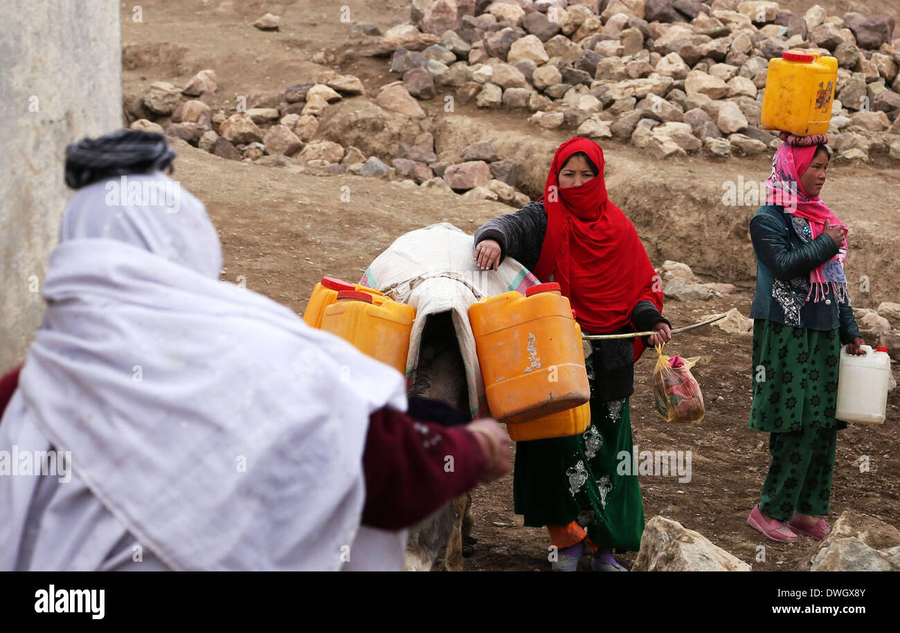 Bamiyan, Afghanistan. 8. März 2014. Afghanische Frauen tragen Barrel Wasser in Richtung ihrer Häuser in Bamyan Provinz, Zentralafghanistan, 8. März 2014. © Kamran/Xinhua/Alamy Live-Nachrichten Stockfoto