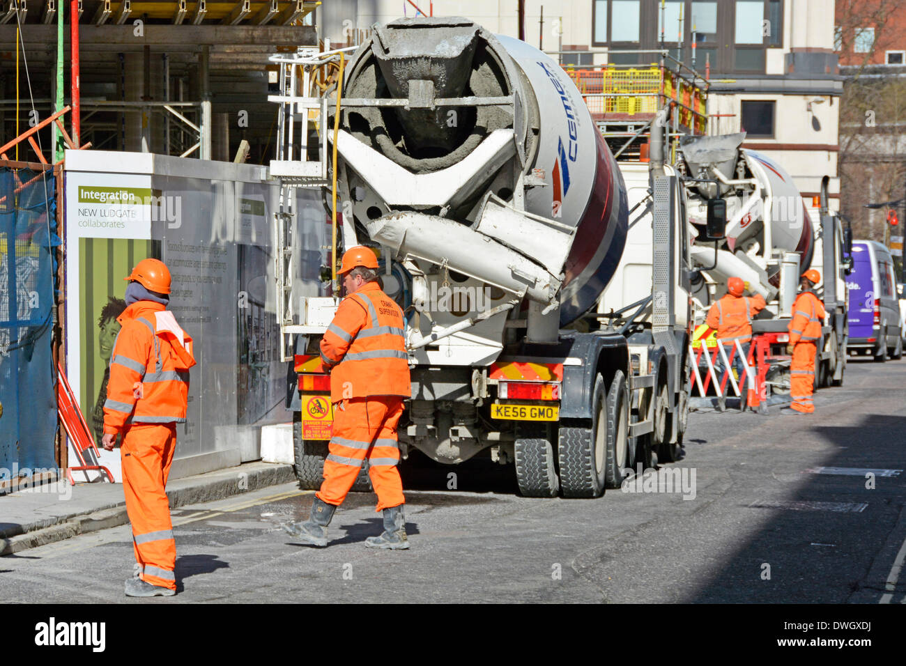 Verkehrsmarschalls auf der Baustelle überwachen den Verkehrsfluss von Betonzementlastwagen, die mit einem Kran auf der öffentlichen Autobahn London UK entladen werden Stockfoto