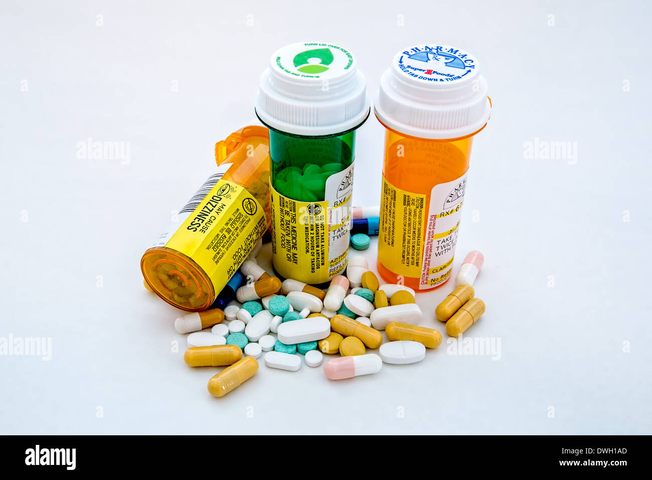 Rezept-Tablettenfläschchen und gemischte Pillen herumliegen Stockfoto