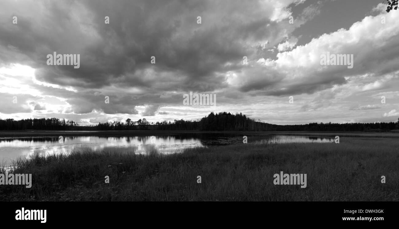 Wolken über einem See in der Nähe von Langviksmon in Anundsjö, Västernorrland, Schweden. Schwarz / weiß Fotografie. Stockfoto