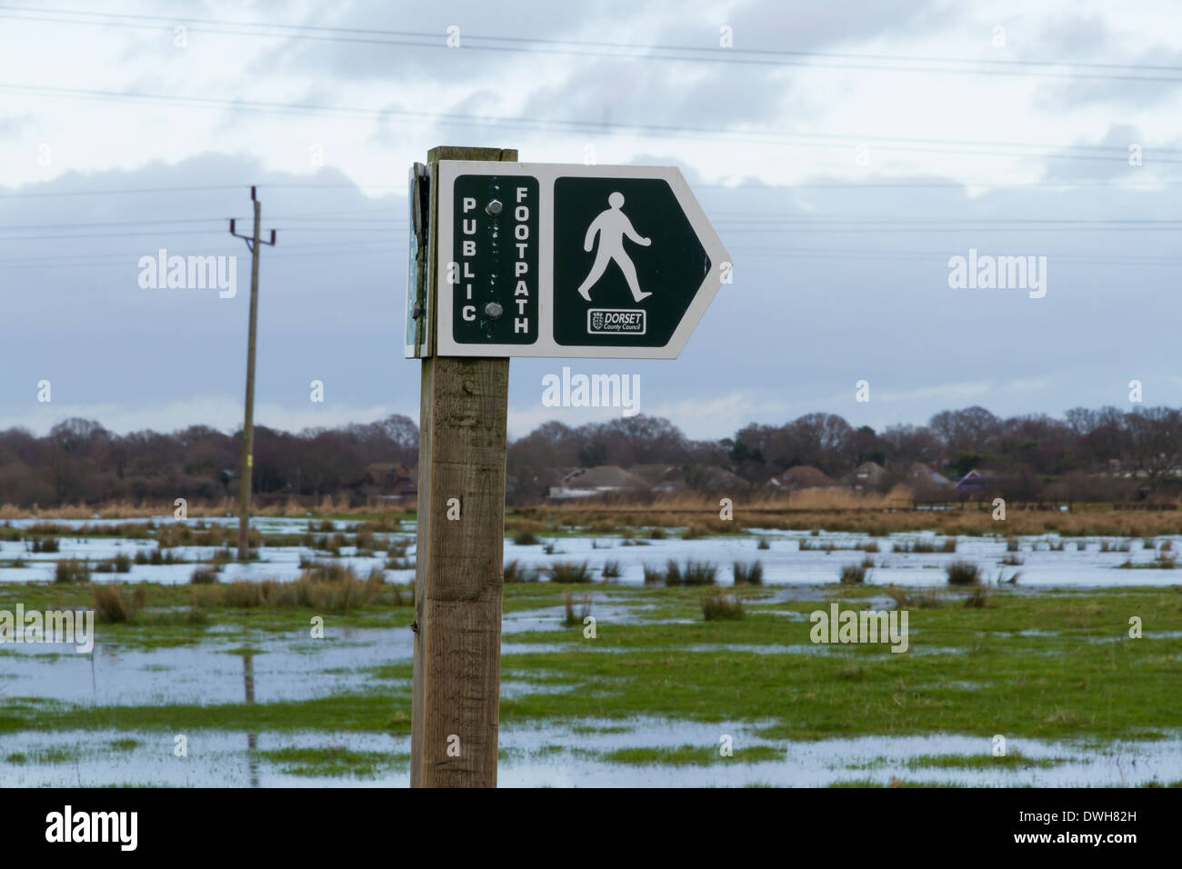 Dorset County Council Fußweg Zeichen, überflutete Christchurch Wiesen im Hintergrund. Dorset, England, Vereinigtes Königreich. Stockfoto