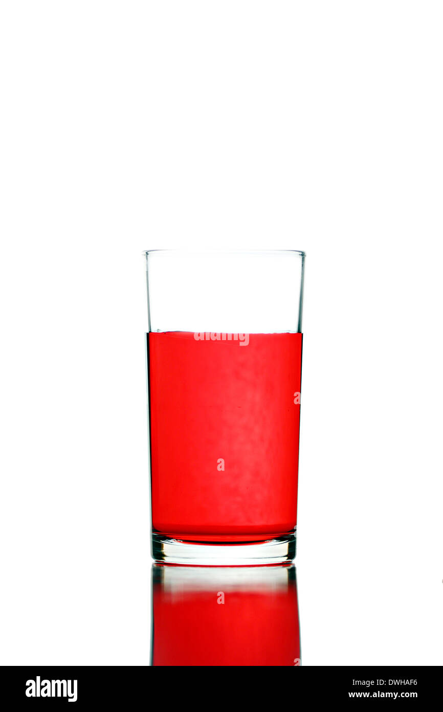 Rotes Wasser im Glas isoliert auf weißem Hintergrund. Stockfoto