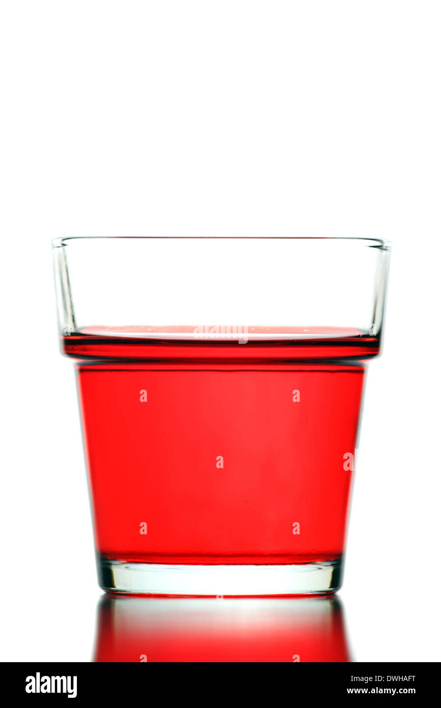 Rotes Wasser im Glas isoliert auf weißem Hintergrund. Stockfoto