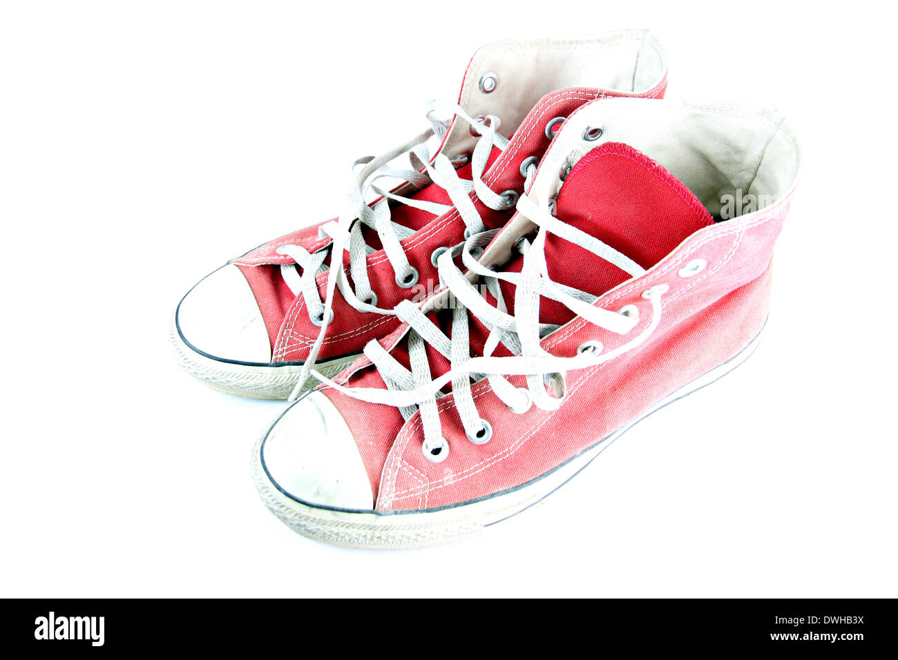 Schmutzige rote Sneaker isoliert auf weißem Hintergrund. Stockfoto