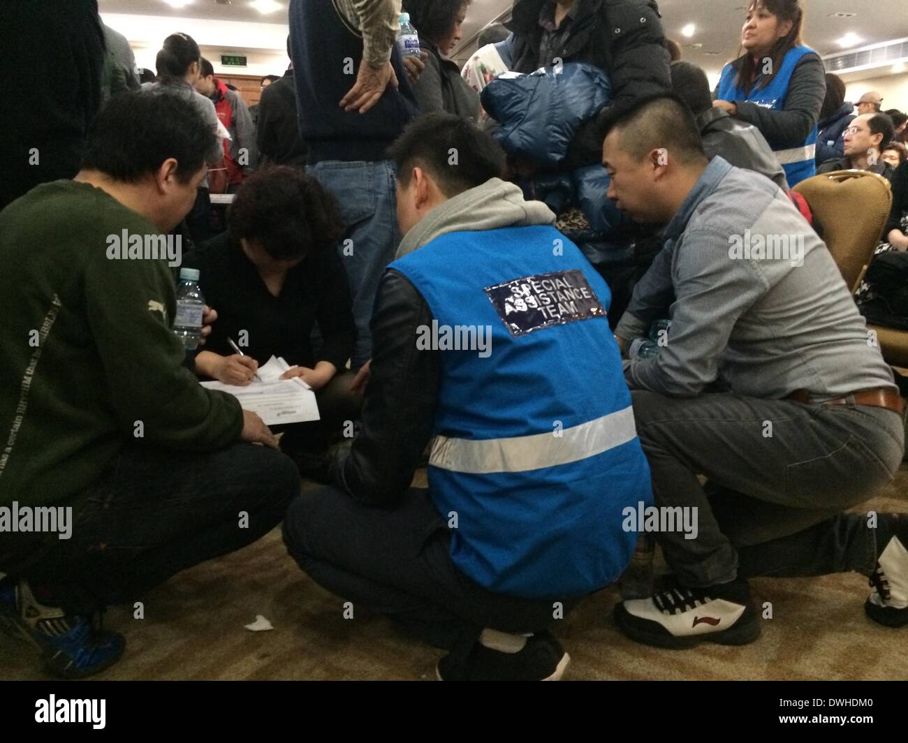 Peking, China. 9. März 2014. Angehörigen der an Bord des fehlenden Fluges füllt ein Formular bei einem Follow-up-treffen in Peking, Hauptstadt von China, 9. März 2014. Die Airline-Sprecher sagte, das Unternehmen Verwandten auf die aktuelle Situation in alle 15 Minuten aktualisiert wird. Malaysia Airlines Flug MH370, eine Boeing B777-200, verloren Kommunikation und Radar-Signal auf dem Flug von Malaysias Hauptstadt Kuala Lumpur nach Peking am frühen Samstagmorgen. An Bord befanden sich 227 Passagiere aus 14 Ländern, einschließlich 154 Chinesisch und 12 malaysischen Flugbesatzung. Bildnachweis: Luo Xiaoguang/Xinhua/Alamy Live-Nachrichten Stockfoto