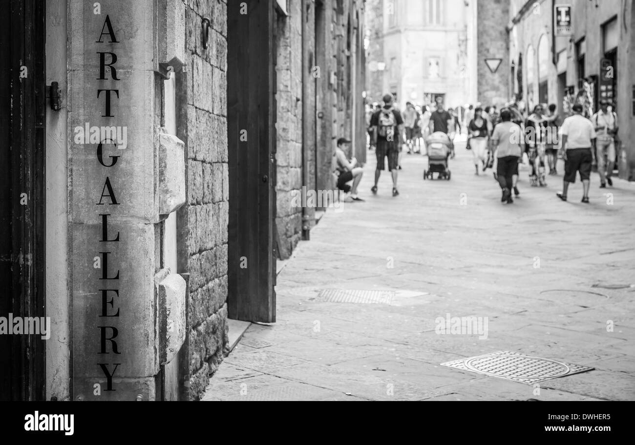 Toskana, Italien. Eine Kunst-Galerie-Signseen in einer Straße voller Turism. Stockfoto