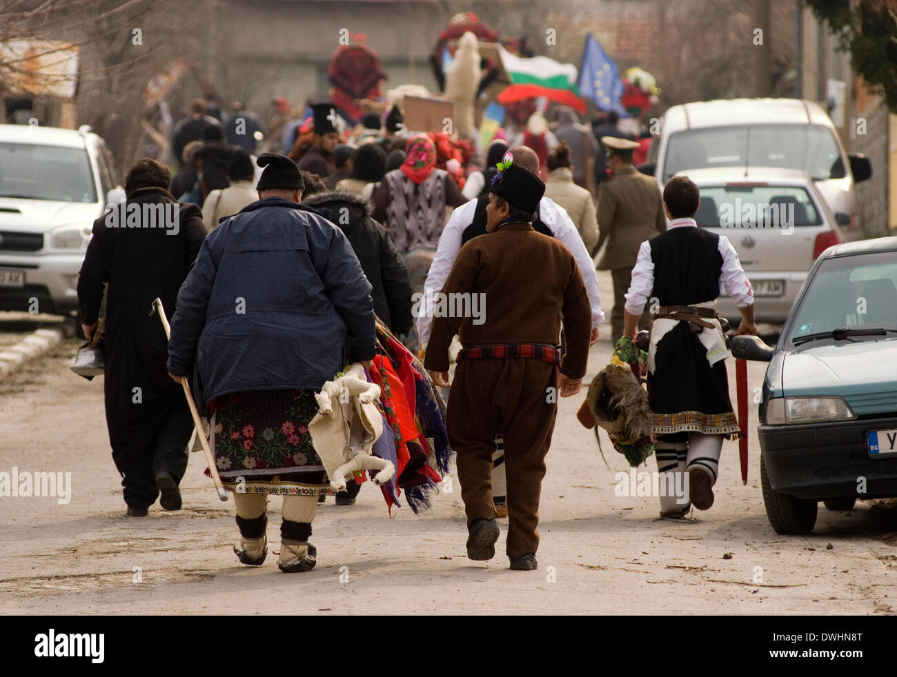 Bulgarien Boyannovo 9. März 2014: Männer, Frauen und Kinder auf die Straße gehen und marschieren um Boyanovo weht Pfeifen und schreien tragen Kostüm Kleid der Kukeri und tragen Masken, um böse Geister zu vertreiben und wünschen Gesundheit und Wohlstand auf einzelne vor der jährlichen Parade auf dem Stadtplatz Credit: Clifford Norton/Alamy Live News Stockfoto