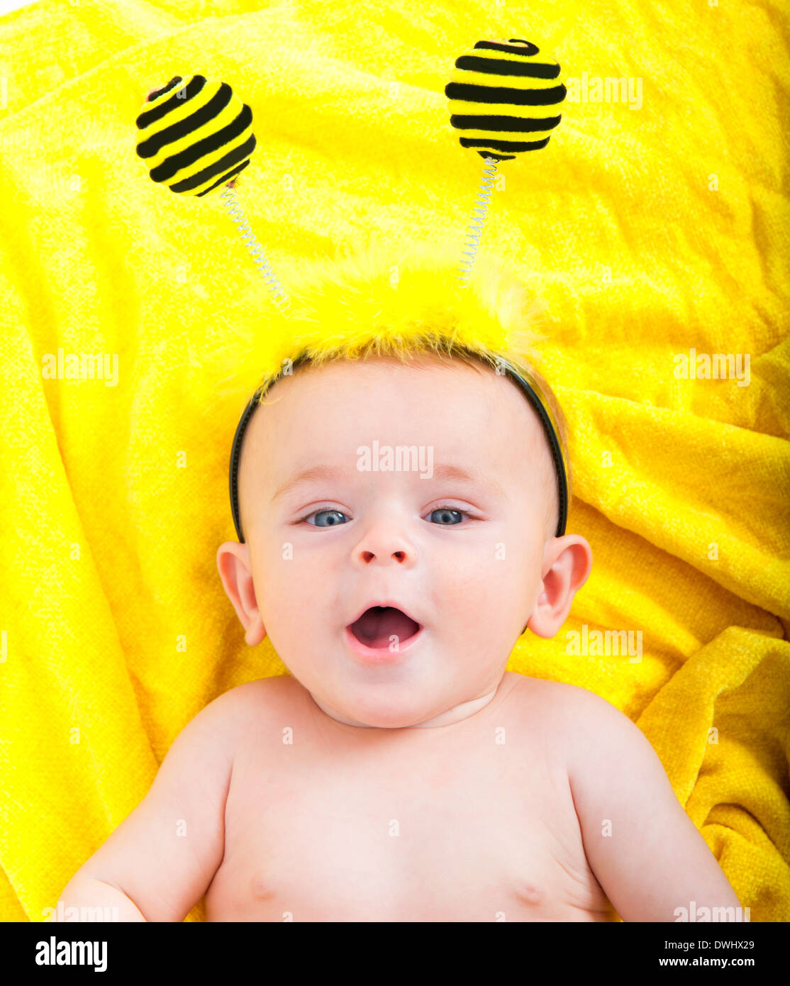 Niedliche Baby Boy auf ein gelbes Tuch liegend Stockfoto