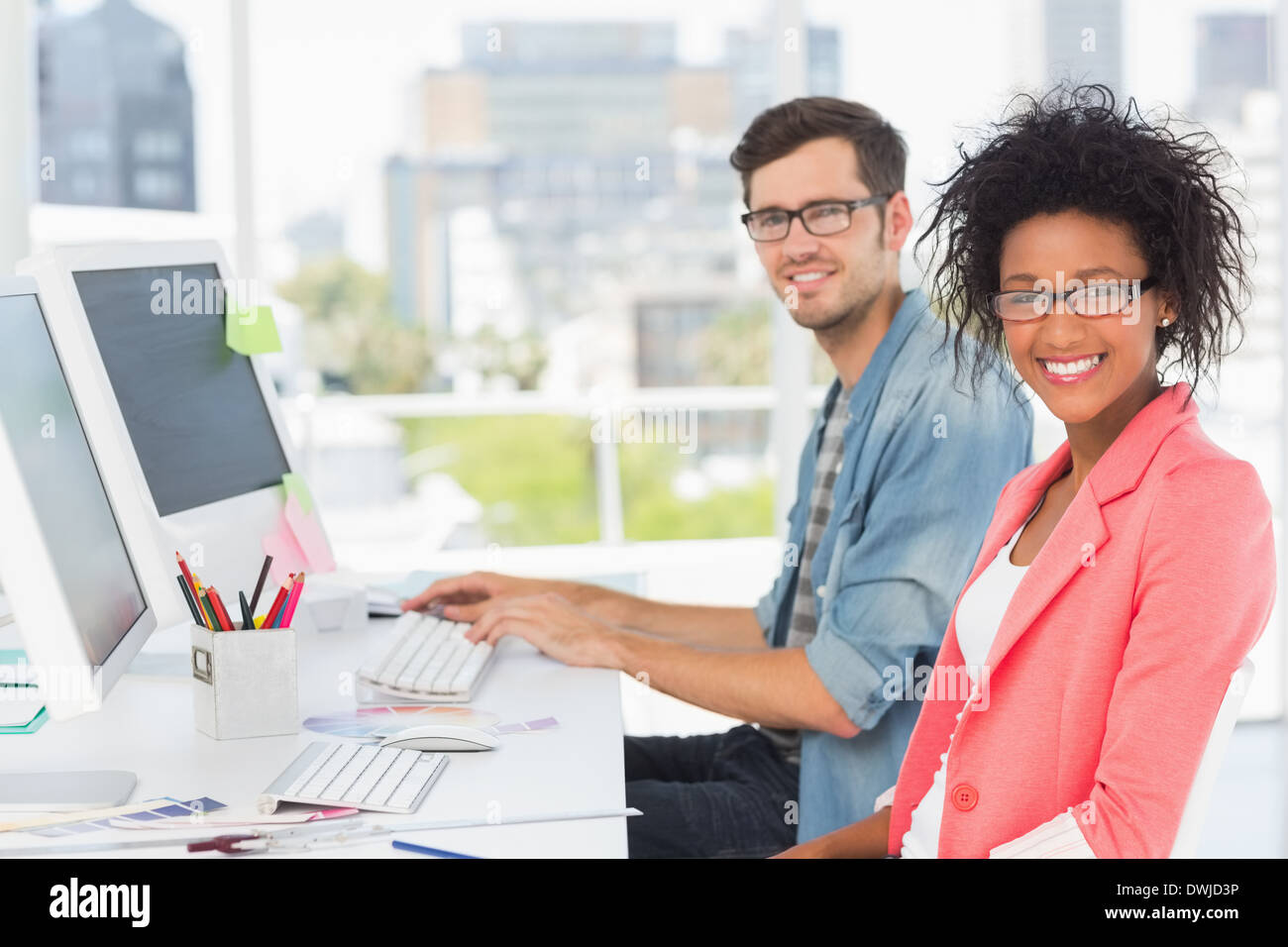 Lächelnd lässig junges Paar, die auf dem Computer arbeiten Stockfoto