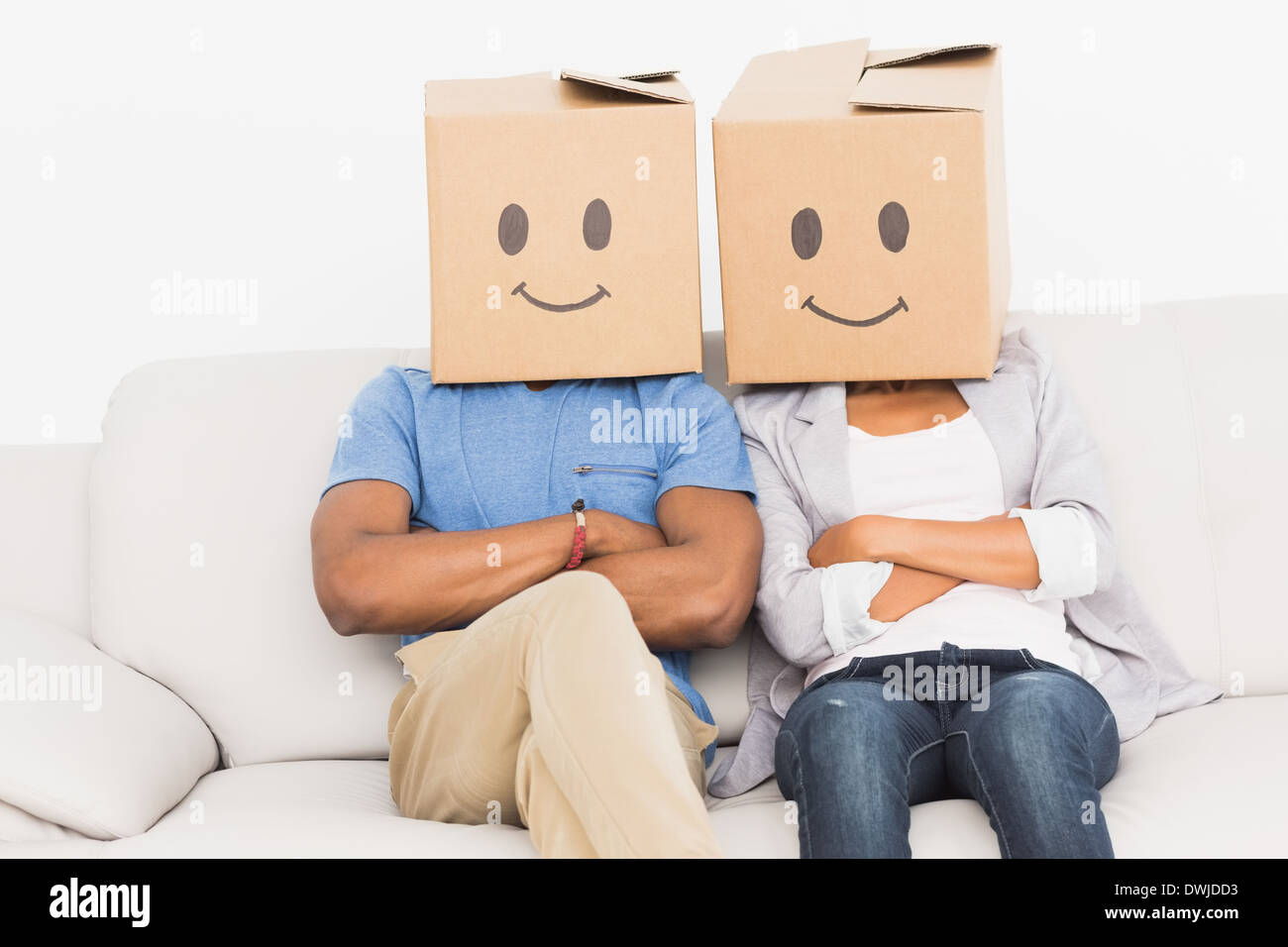 Junges Paar mit glücklichen Smiley-Boxen über Gesichter Stockfoto