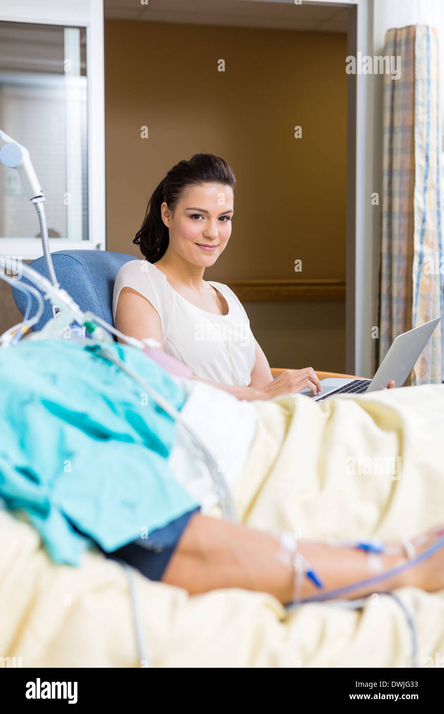 Frau mit Laptop sitzen durch männliche Patienten Stockfoto
