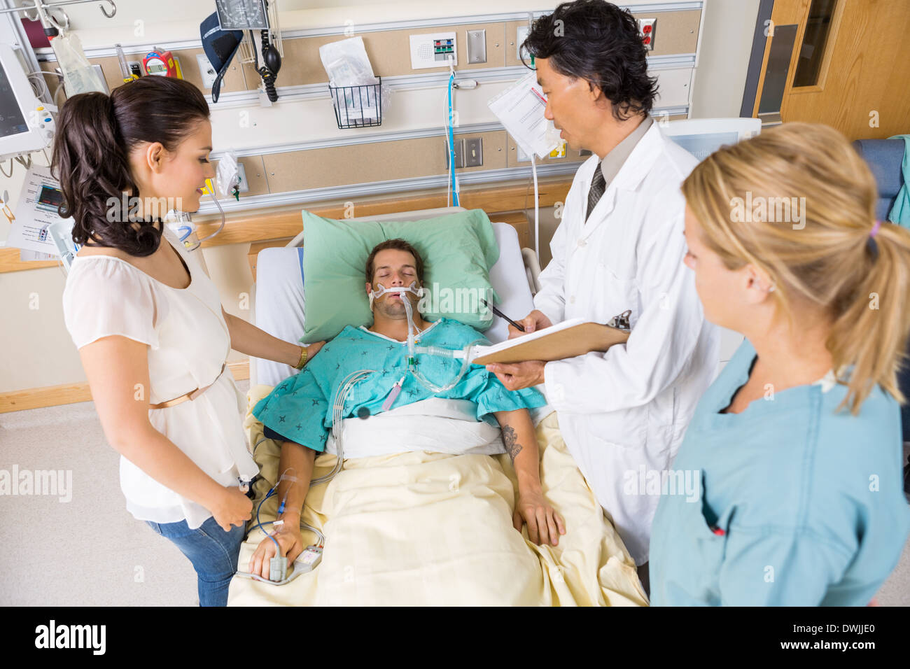 Arzt und Krankenschwester mit Frau betrachten kritische Patienten Stockfoto