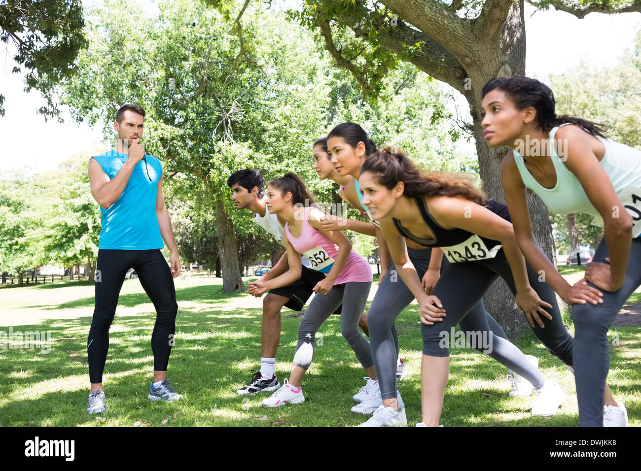 Trainer, Pfeifen, während Läufer Rennen bereit Stockfoto