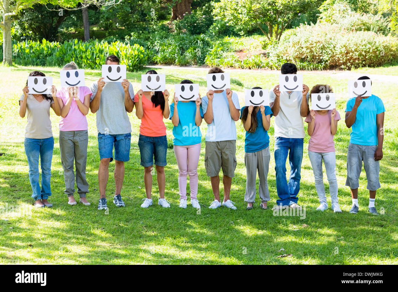 Multiethnische Freunde halten Smileys im park Stockfoto