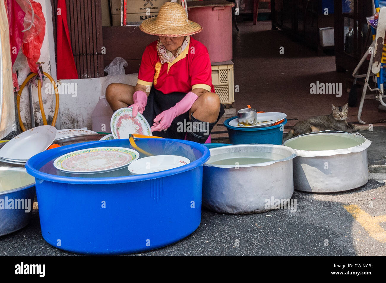 Eine Dame beim Abwasch in Malacca Stockfoto