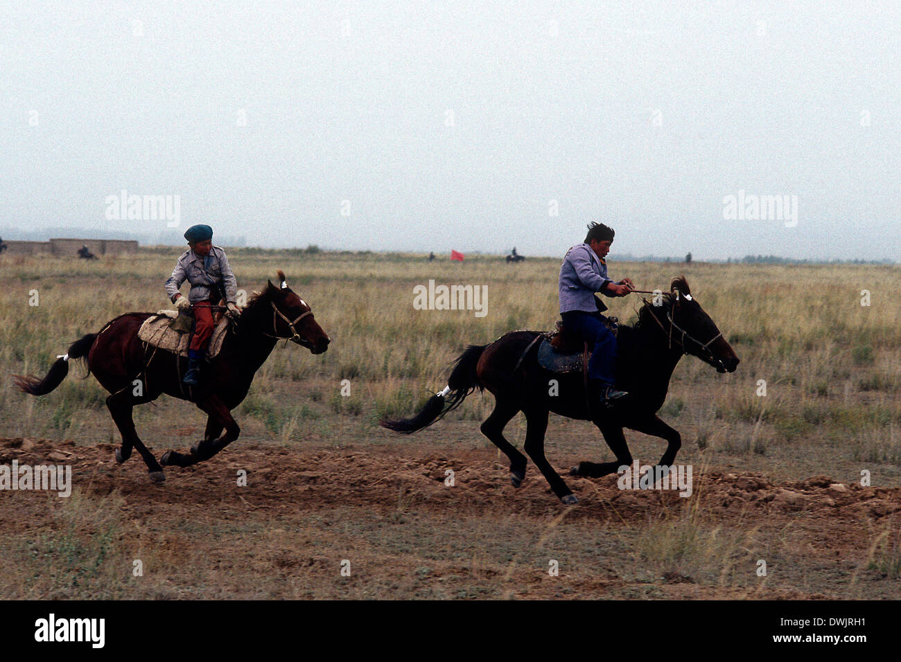 Zwei kasachische Reiter in einem Rennen am Yinning, Kasachstan, in der Nähe der alten sowjetischen russischen Grenze. Stockfoto