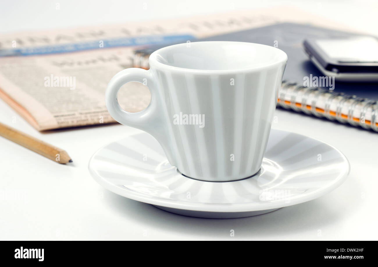Kaffeetasse mit Zeitung und Smartphone am Bürotisch Stockfoto